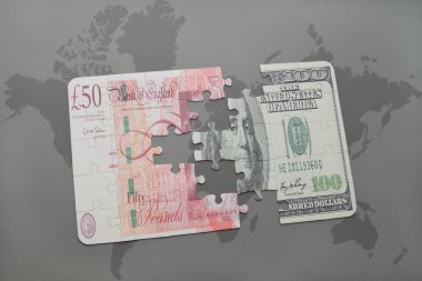 İngiliz Sterlini ve Doları banknot dünya harita arka plan üzerinde bulmaca.