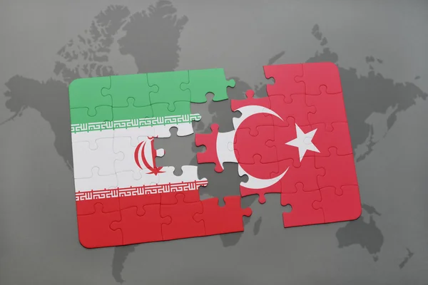 Bir dünya haritası arka plan üzerinde İran ve Türkiye'nin ulusal bayrağı ile bulmaca. — Stok fotoğraf