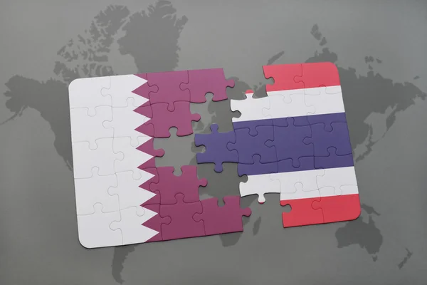 Puzzel met de nationale vlag van Qatar en Thailand op een wereld kaart achtergrond. — Stockfoto