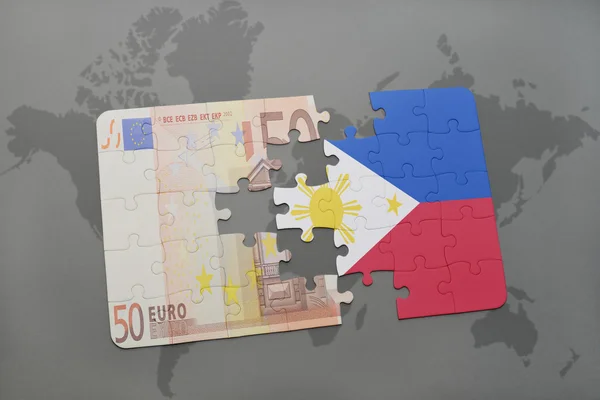 Quebra-cabeças com a bandeira nacional de filipinas e notas de euro sobre um fundo de mapa mundial . — Fotografia de Stock