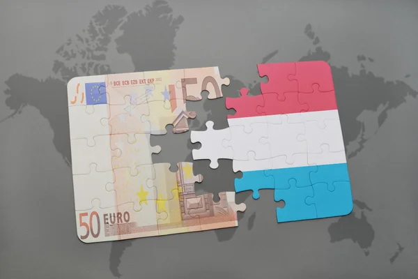 世界地图背景上与卢森堡国旗和欧元钞票的拼图. — 图库照片