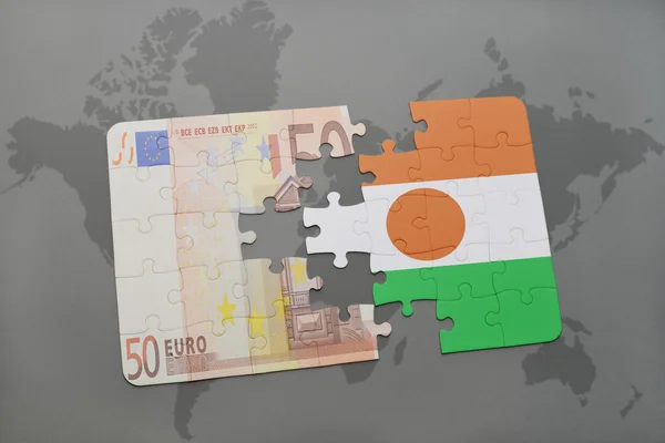Puzzle avec le drapeau national du niger et le billet en euros sur un fond de carte du monde . — Photo