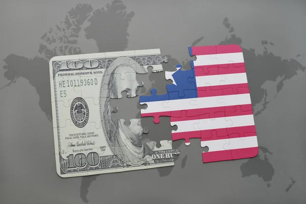 Rompecabezas con la bandera nacional de Liberia y el billete de dólar en un mapa del mundo fondo . — Foto de Stock