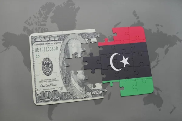 Puzzel met de nationale vlag van Libië en dollar biljet op een wereld kaart achtergrond. — Stockfoto