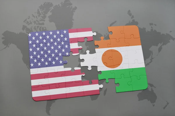 Puzzle with the national flag of united states of america and niger on a world map background. — Stock Photo, Image