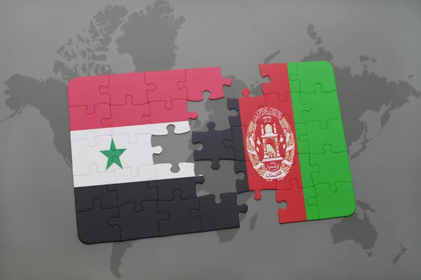 Puzzel met de nationale vlag van Syrië en Afghanistan op een wereld kaart achtergrond. — Stockfoto