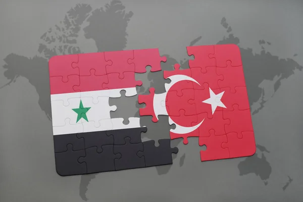 Puzzle avec le drapeau national de la syrie et de la dinde sur un fond de carte du monde . — Photo