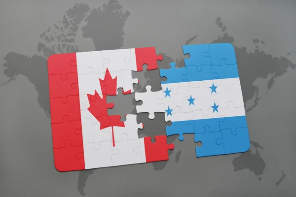 Quebra-cabeça com a bandeira nacional do Canadá e honduras em um fundo de mapa do mundo . — Fotografia de Stock