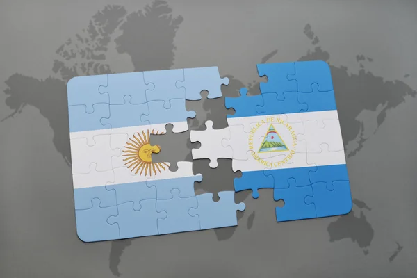 Puzzle with the national flag of argentina and nicaragua on a world map background. — Stock Photo, Image