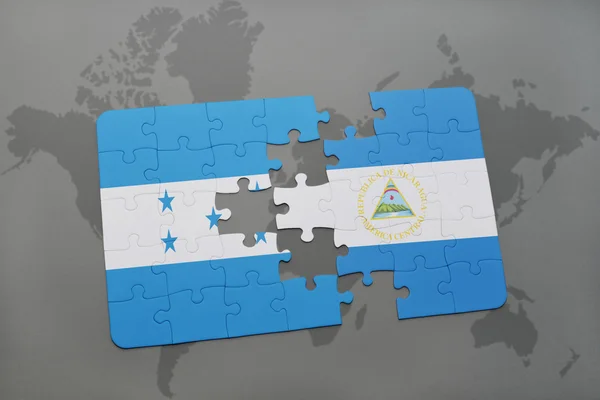 Rompecabezas con la bandera nacional de honduras y nicaragua en un mapa del mundo fondo . — Foto de Stock