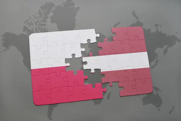 Puzzel met de nationale vlag van Polen en Letland op een wereld kaart achtergrond. — Stockfoto