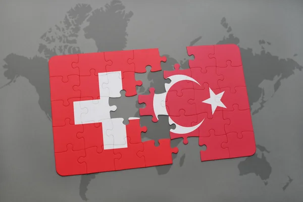 Bir dünya haritası arka plan üzerinde İsviçre ve Türkiye ulusal bayrağı ile bulmaca. — Stok fotoğraf