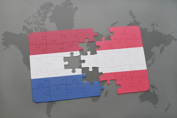 Bir dünya haritası arka plan üzerinde Hollanda ve Avusturya ulusal bayrağı ile bulmaca. — Stok fotoğraf