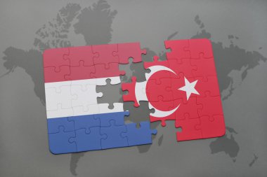 bir dünya haritası arka plan üzerinde Hollanda ve Türkiye ulusal bayrağı ile bulmaca.