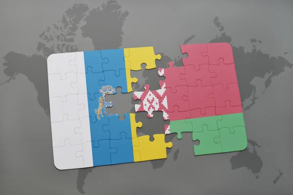 Puzzle avec le drapeau national des îles Canaries et Belarus sur un fond de carte du monde . — Photo