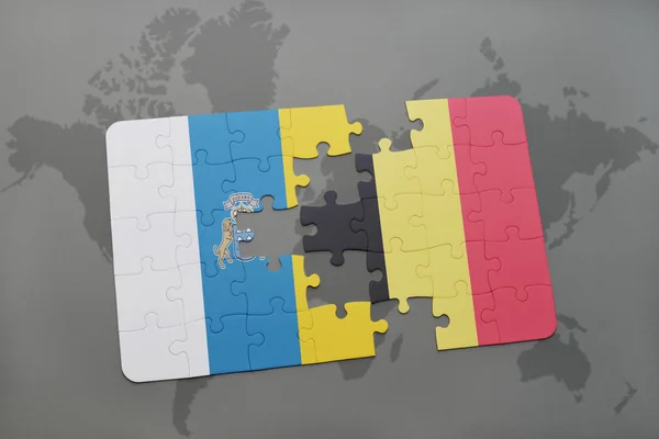 Puzzel met de nationale vlag van de Canarische eilanden en België op een wereld kaart achtergrond. — Stockfoto