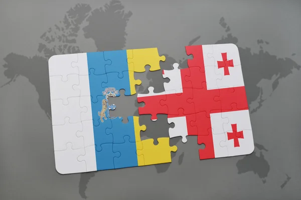 Quebra-cabeça com a bandeira nacional de ilhas canárias e georgia em um fundo de mapa do mundo . — Fotografia de Stock
