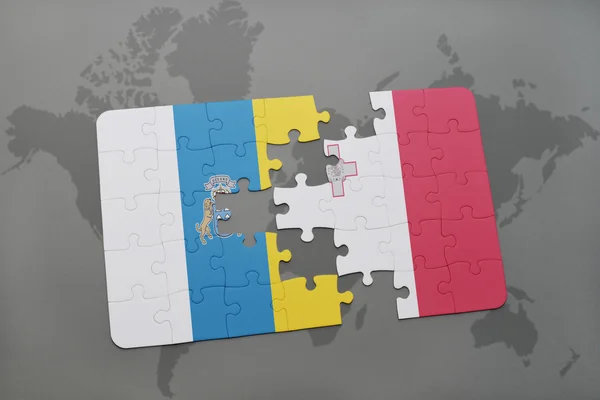 Puzzel met de nationale vlag van de Canarische eilanden en Malta op een wereld kaart achtergrond. — Stockfoto