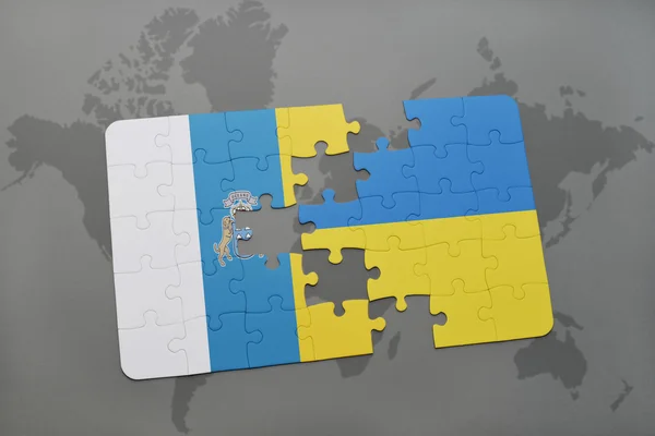 Puzzle con la bandiera nazionale delle isole canarie e ucraina su uno sfondo mappa del mondo . — Foto Stock