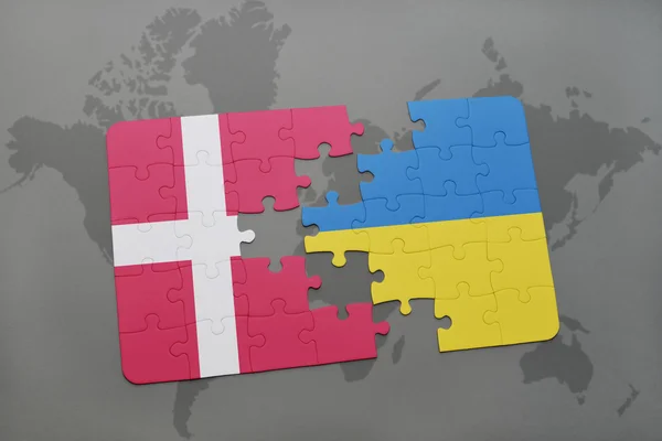 Головоломка з національним прапором Данії та України на тлі світової карти. — стокове фото