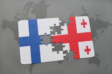 bir dünya haritası arka plan üzerinde Finlandiya ve Gürcistan ulusal bayrağı ile bulmaca.