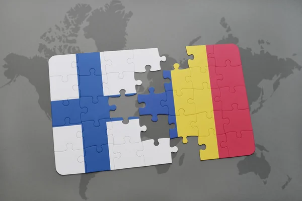 Puzzle avec le drapeau national de la Finlande et la Roumanie sur un fond de carte du monde . — Photo