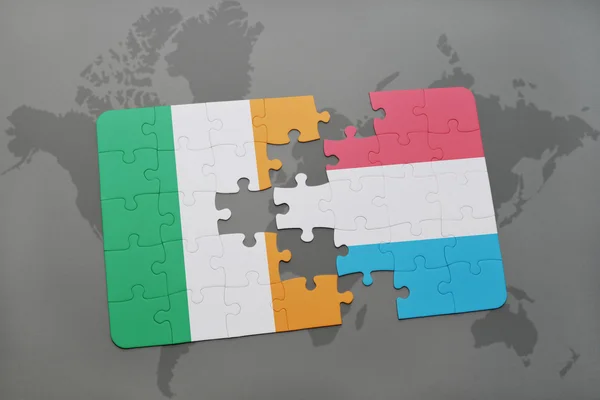 Puzzle con la bandiera nazionale di Irlanda e Lussemburgo su uno sfondo mappa del mondo . — Foto Stock