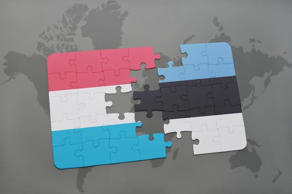 Puzzel met de nationale vlag van Luxemburg en Estland op de achtergrond van een wereld kaart. — Stockfoto