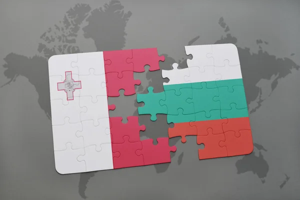 Malta ve Bulgaristan Ulusal bayrak dünya harita arka plan üzerinde ile bulmaca. — Stok fotoğraf
