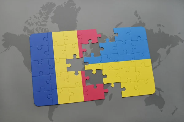 Puzzel met de nationale vlag van Roemenië en Oekraïne op de achtergrond van een wereld kaart. — Stockfoto