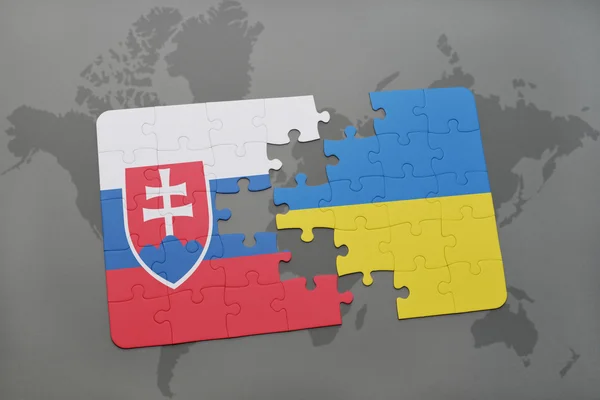 Головоломка з Національний прапор Словаччини та України на фоні карта світу. — стокове фото