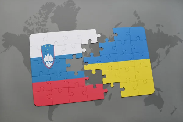 世界地図背景にスロベニアとウクライナの国旗パズルします。. — ストック写真