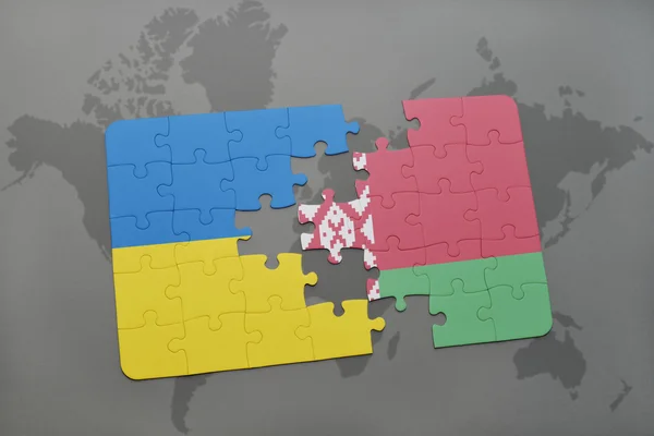 Puzzel met de nationale vlag van Oekraïne en Wit-Rusland op de achtergrond van een wereld kaart. — Stockfoto