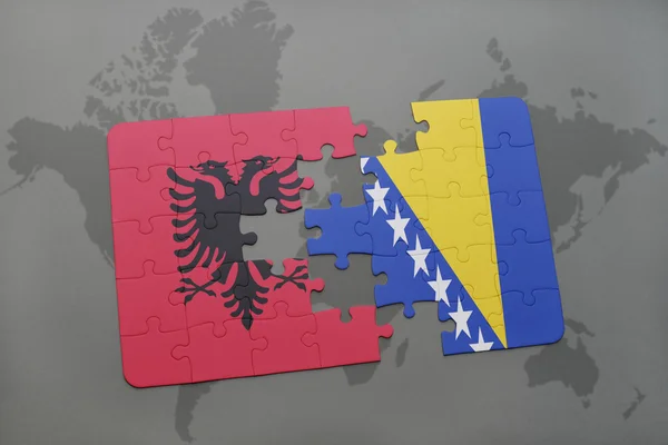 Puzzel met de nationale vlag van Albanië en Bosnië en Herzegovina op een wereld kaart achtergrond. — Stockfoto