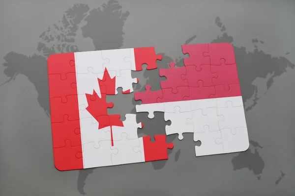 Quebra-cabeça com a bandeira nacional do Canadá e indonésia em um fundo de mapa do mundo . — Fotografia de Stock