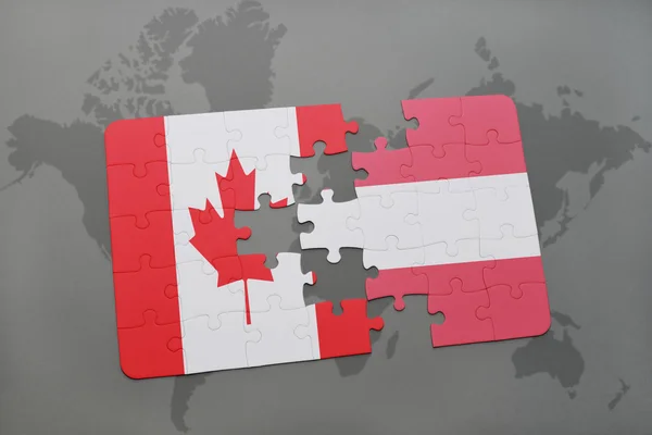 Puzzle con la bandiera nazionale del Canada e dell'Austria sullo sfondo di una mappa del mondo . — Foto Stock