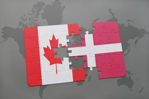 Puzzle s národní vlajkou Kanady a Dánska na pozadí světové mapy. — Stock fotografie