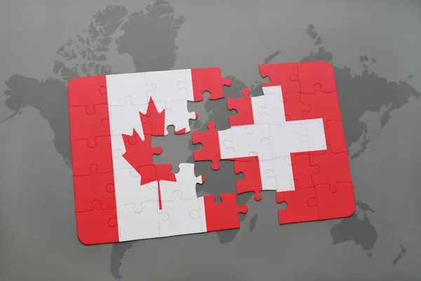 Puzzel met de nationale vlag van Canada en Zwitserland op een wereld kaart achtergrond. — Stockfoto