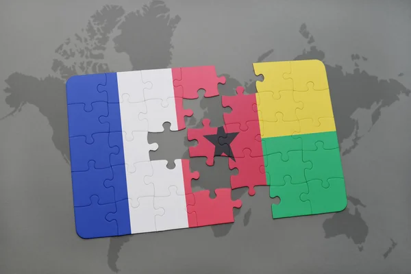 世界地图背景上法国和几内亚比绍国旗的拼图. — 图库照片