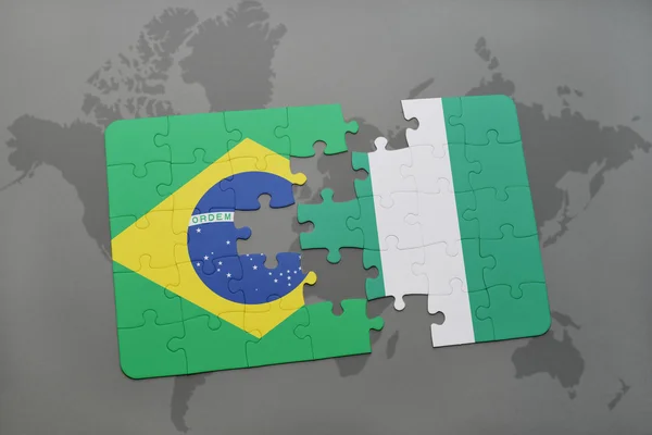 Rompecabezas con la bandera nacional de Brasil y Nigeria en un mapa del mundo de fondo . —  Fotos de Stock