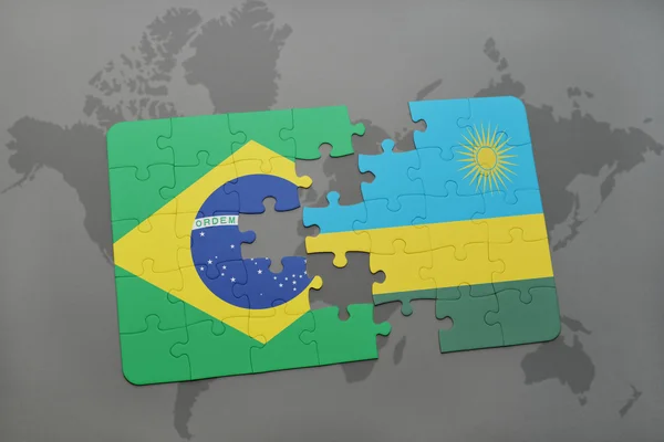 Rompecabezas con la bandera nacional de Brasil y Ruanda en un mapa del mundo de fondo . —  Fotos de Stock