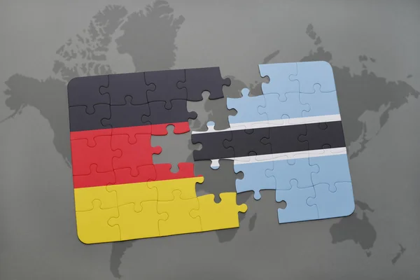 Puzzel met de nationale vlag van Duitsland en Botswana op een wereld kaart achtergrond. — Stockfoto