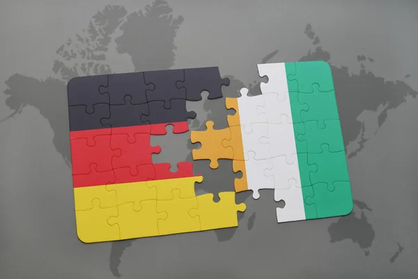 Quebra-cabeça com a bandeira nacional da alemanha e cote divoire em um fundo de mapa do mundo . — Fotografia de Stock