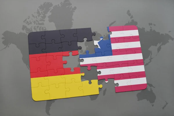 Rompecabezas con la bandera nacional de Alemania y Liberia en un mapa del mundo de fondo . — Foto de Stock