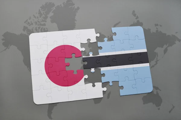 Puzzle with the national flag of japan and botswana on a world map background. — Stock Photo, Image