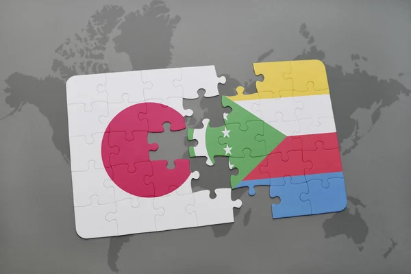 Puzzle avec le drapeau national du Japon et des comores sur un fond de carte du monde . — Photo