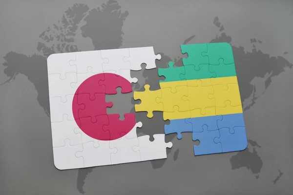 Puzzle avec le drapeau national du Japon et du Gabon sur fond de carte du monde . — Photo