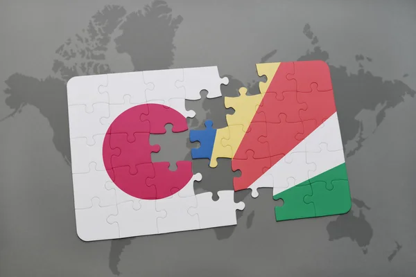 Puzzel met de nationale vlag van Japan en de Seychellen op een wereld kaart achtergrond. — Stockfoto