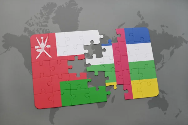 Puzzle con la bandiera nazionale della repubblica omana e centrafricana sullo sfondo di una mappa del mondo . — Foto Stock