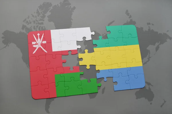 Puzzel met de nationale vlag van Oman en Gabon op een wereld kaart achtergrond. — Stockfoto